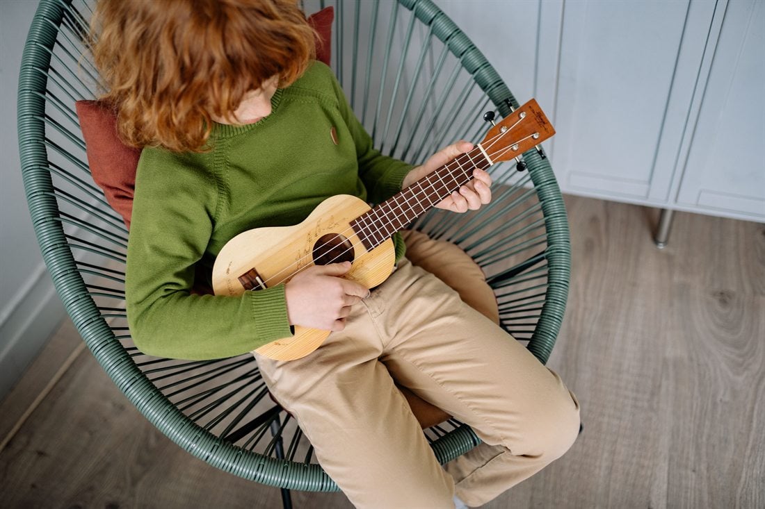 Student practicing ukulele at home
